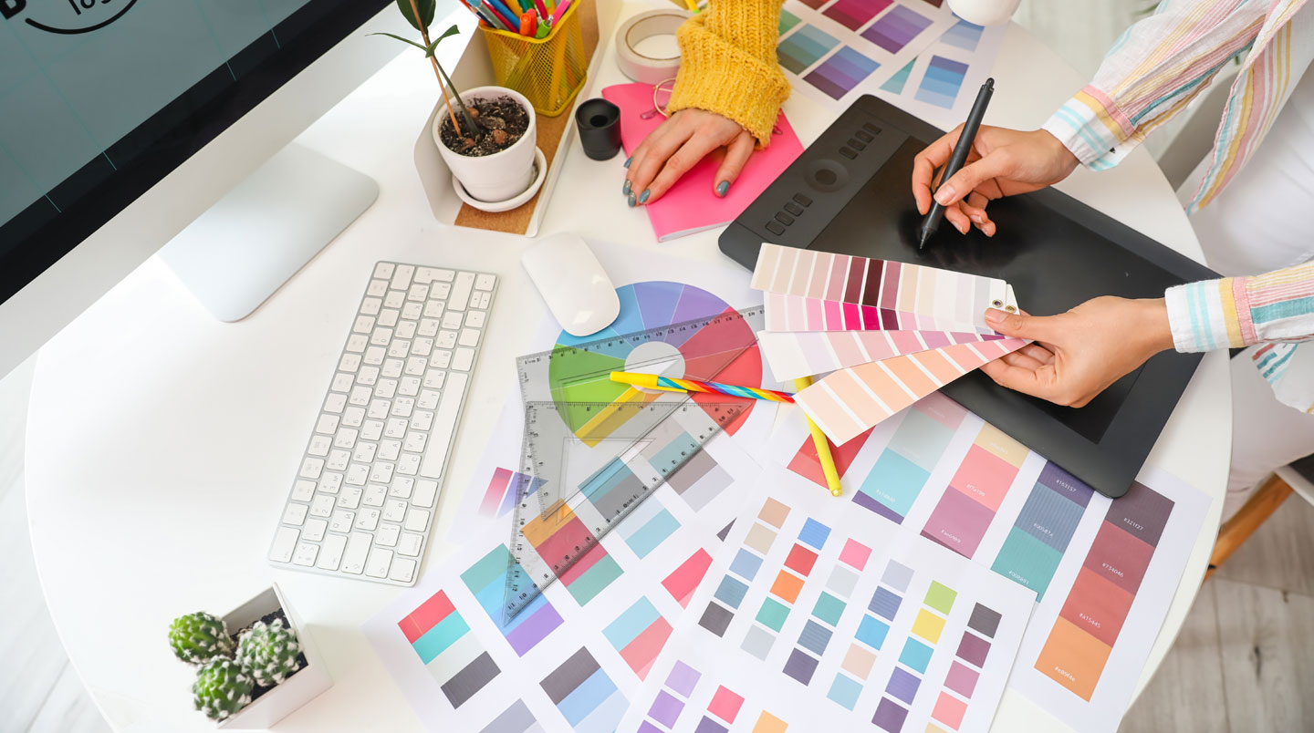 Extreme close-up of color palette swatches and brand guideline materials arranged on a clean white desk surface